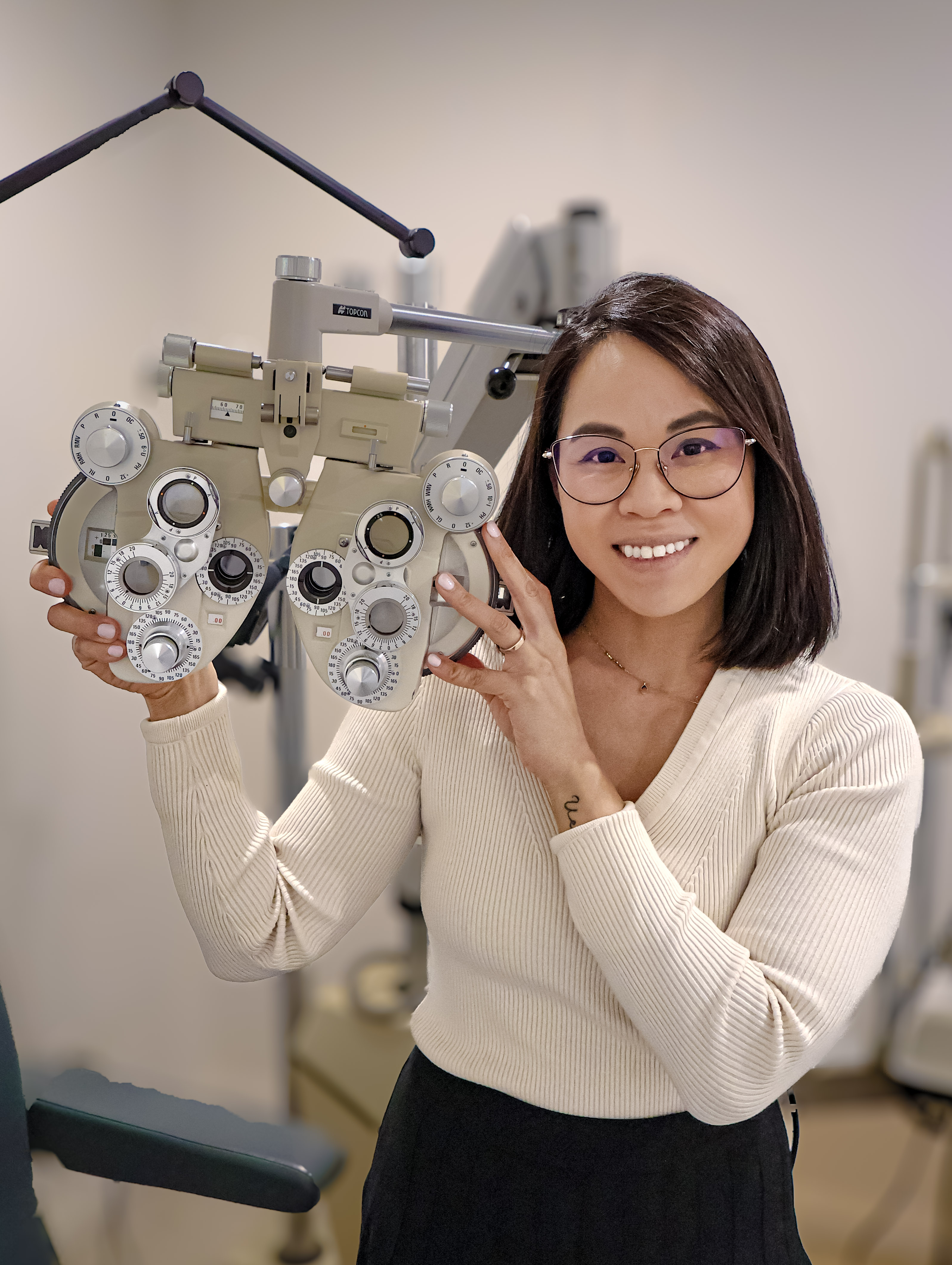 Dr. Sarah Fong holding a phoropter during an eye exam